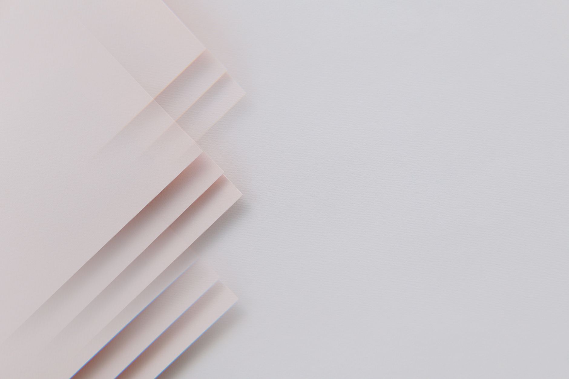 Layered sheets of paper resting on a grey surface